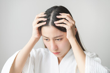 Damaged Hair symptom, face serious asian young woman, girl worry about balding, looking at scalp in mirror, hand in break into front hair loss, thin problem. Health care treatment for beauty concept.