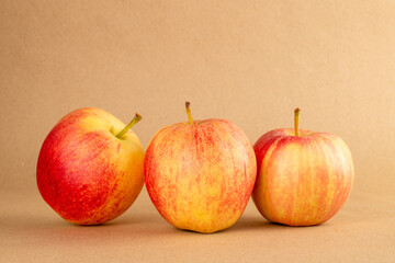 Three red apples on kraft paper, macro.