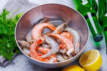 Fresh raw shrimps, accompanied by sprigs of fresh parsley and juicy lemon
