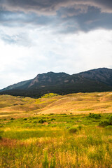 Rolling hills with a distant mountain under a cloudy sky.