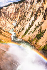 Vibrant canyon view with flowing river and rainbow