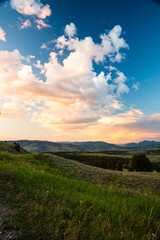 Vivid clouds float above hills at sunset in Yellowstone National Park.