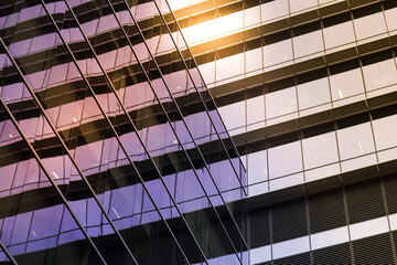 Reflective glass windows of a modern geometric building in sunlight - Powered by Adobe