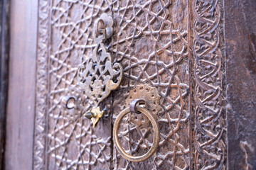 A wooden door with a gold and silver lock