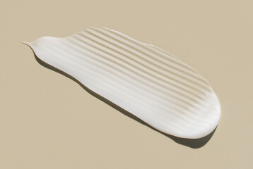 creamy smear of white cosmetic texture on beige background skin care concept