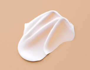 creamy smear of white cosmetic texture on beige background skin care concept