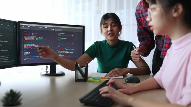 Slow motion back end software developer engineer for computer programming working together on debugging writing computing code, solving complex algorithms display on monitor in office. Burgeoning