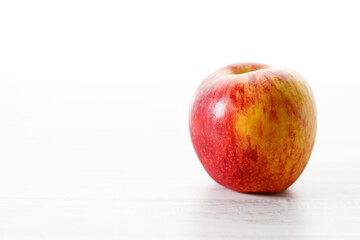 Ripe organic red apple on white table background.