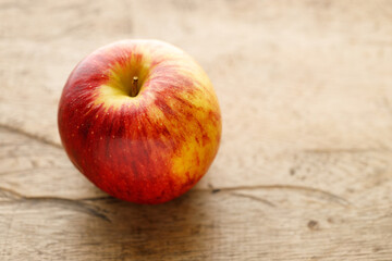 Ripe organic red apple on wooden table background.