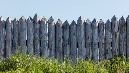 Obraz premium Wooden log fence against the sky