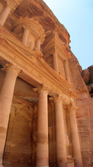 Standing under the giant columns of al-Khazneh or The Treasury ancient temple carved in rock in Petra, Jordan