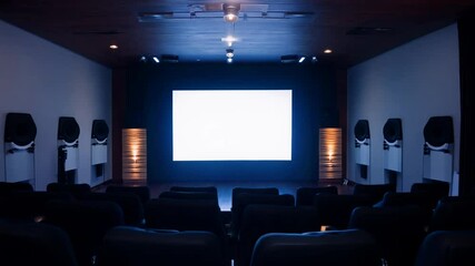 Camera slowly zooms out from a dimly lit home theater with tiered seating, a large projector screen, a surround sound speakers, illuminated by a single spotlight on the screen.