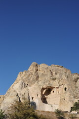 Landscape with caves in limestone (sandstone) mountains with rock-cut churches, chapels and monasteries and blue sky in summer in G&ouml;reme Open Air museum, Cappadocia, Anatolia, Turkey (G&ouml;reme &ouml;ren yeri