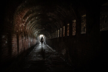 Naklejka premium lady female tourist walks through Stenen Beer stone bear part of fortification with walkable tunnel passageway Veere, Zeeland, Netherlands