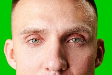 Close-Up Portrait Of A Man With Green Eyes Against A Bright Green Background