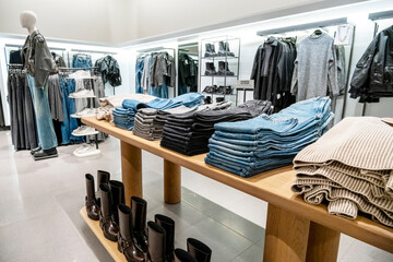 There are jeans, warm jumpers, boots and other clothes on the shelves in the shopping centre. Russia Moscow 6 September 2024