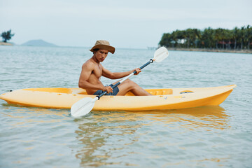 Joyful Asian Man Kayaking on a Tropical Beach: Embracing the Summer Adventure