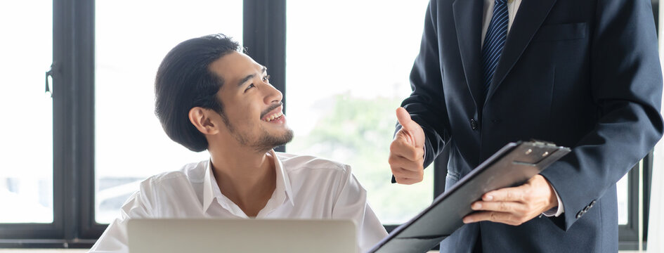Young employee encouraging by his boss at work.