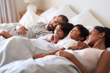Family, sleep and tired in bed for bonding, relax and support together with mother, father and...