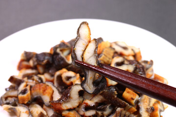 皿に盛った刻み穴子を食べる