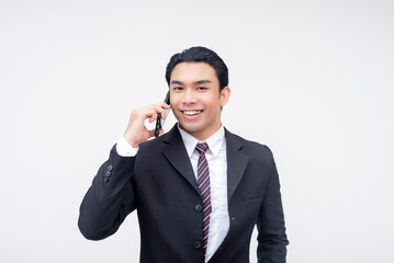 A young businessman smiling at camera while calling a client on his phone. Isolated on a white background.