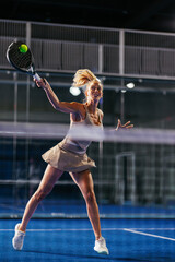 Athletic shot of a female padel player mid-shot © bernardbodo