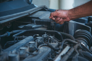 Obraz premium Close up Mechanic man hands repairing car auto repair shop uses jack change tyre. Man hands fixing Shock absorber machinery vehicle mechanical service. Vehicle Car overhaul maintenance engineer