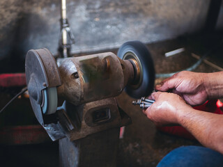 Close up Car Mechanic man hands repairing car auto repair shop. Man hands fixing machinery vehicle...