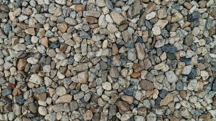 High-resolution close-up image of small pebbles and stones in various shades of gray and brown, ideal for use in backgrounds or textures.