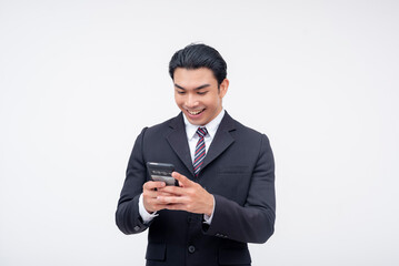 A young asian business executive chatting on his cellphone and smiling. Using a messaging app. Isolated on a white background.