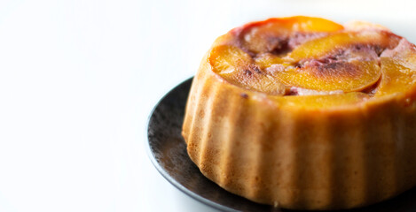 Close up soft focus gluten free peach cake isolated on white with copy space. 