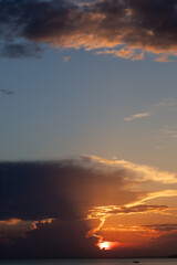 Dramatic clouds with sunlight beams at sunset period, capture from seaside