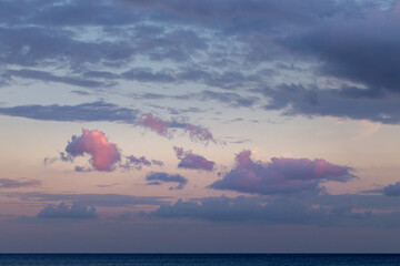 Pink and blue dark clouds at sunset from seaside view