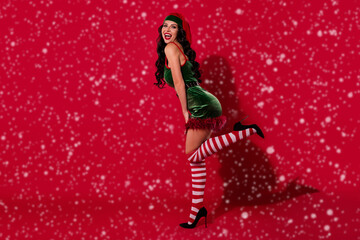 Photo of coquette lady enjoy intimate x-mas wear elf hat costume pantyhose stilettos isolated red...