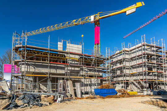 Construction site with crane, scaffolding and shell of an unfinished building