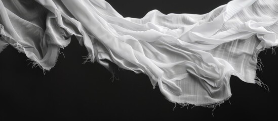 Isolated white fabric with tears and loose threads hanging suitable as a copy space image or texture on a black background