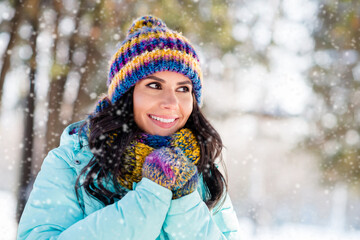 Photo of positive lovely lady warming hands look side wear knitted mittens headwear scarf coat in park outdoors