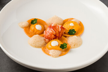 Ravioli with grilled shrimp on a white porcelain plate