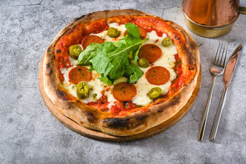 Top view of Neapolitan pizza with sausage, jalapeno peppers and arugula