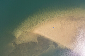 Fototapeta premium Aerial View of Sandbank and Clear Green Waters with Isolated Swimmer 