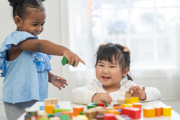Two diverse children playing with colorful wooden blocks early childhood education, learning and...