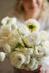 A delicate white bouquet in the hands of the bride. An addition to the wedding look. Floral compositions for the holiday.