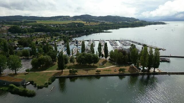 Push in reveal drone shot of the port of Estavayer-le-Lac in the canton of Fribourg in Switzerland with the Lake Neuchatel.