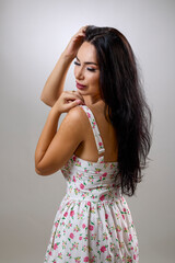 portrait of a beautiful brunette in a summer dress in the studio.