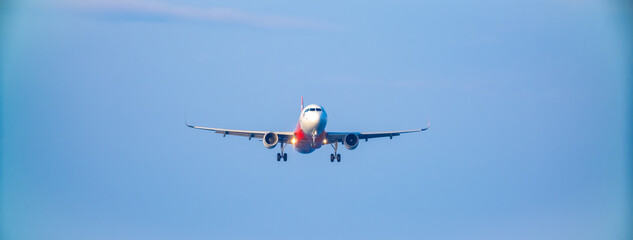 The plane lands over the sea at Phuket airport. A passenger plane lands on Mai Khao Beach, a popular tourist attraction.