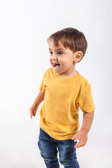 Portrait of a two year old boy looking shy sticking out his tongue while looking away on white background