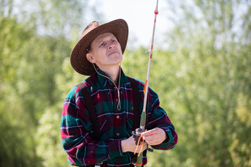 An adult man with a fishing rod while fishing.