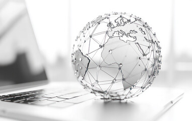 Wireframe globe structure resting on laptop keyboard