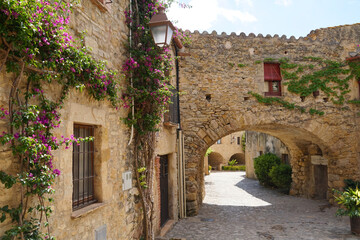 Peratallada, historic centre with small alley, archway and medieval Romanesque buildings at at a sunny day with blue sky, Pals, Begur, Girona, Catalonia, Costa Brava, Spain