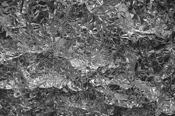 Processed collage of shiny metal silver gray foil crumpled packaging material texture